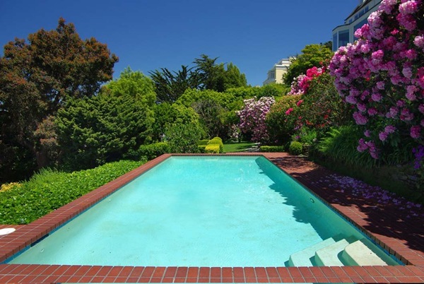 a-heated-outdoor-swimming-pool-and-spa-are-given-privacy-by-its-lush-garden